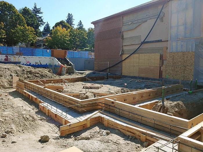 a building with the siding removed and wood forms for concrete stem walls